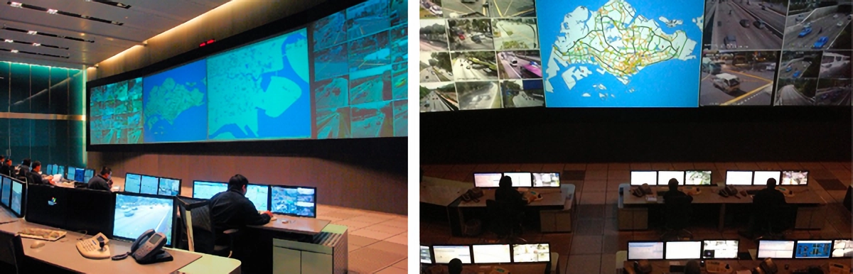A traffic control center with operators at workstations facing large video walls displaying maps and camera feeds.